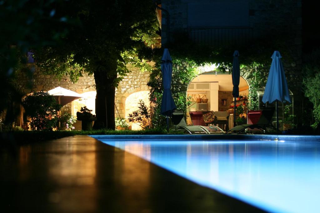 a swimming pool at night with blue lights at Au fil de l'eau in Chambonas