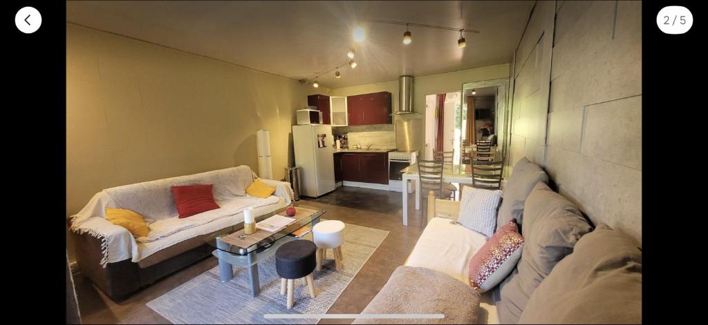 a living room with two couches and a kitchen at Studio cosy in Boutx