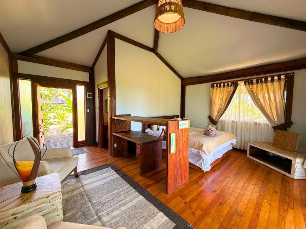 a bedroom with a bed and a couch in a room at Vaihu Nui Bungalow-Glamping in Hanga Roa