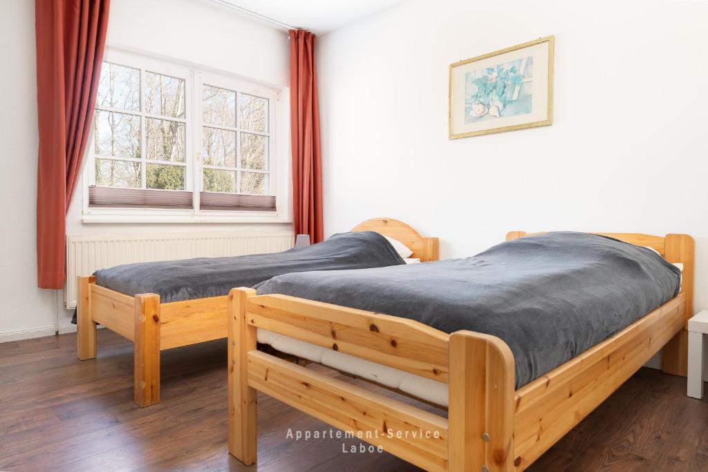 two twin beds in a room with a window at Monteurunterkunft Kuddel in Laboe