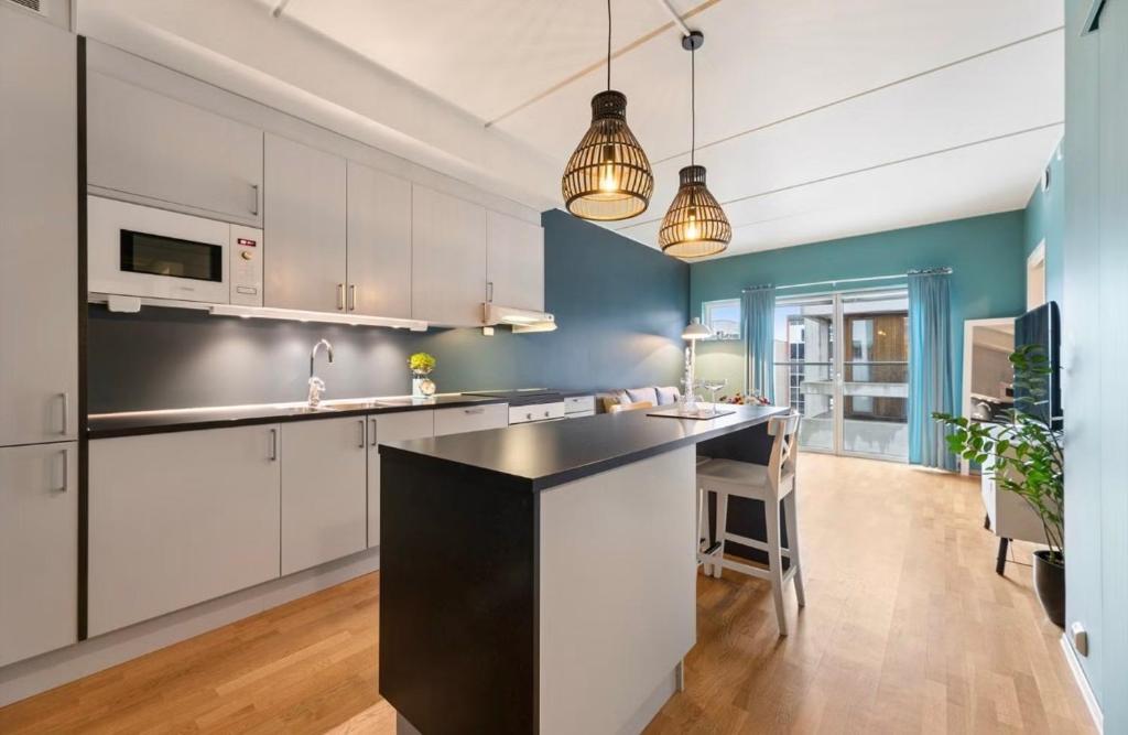 a kitchen with white cabinets and a black counter top at City apartment in Alta