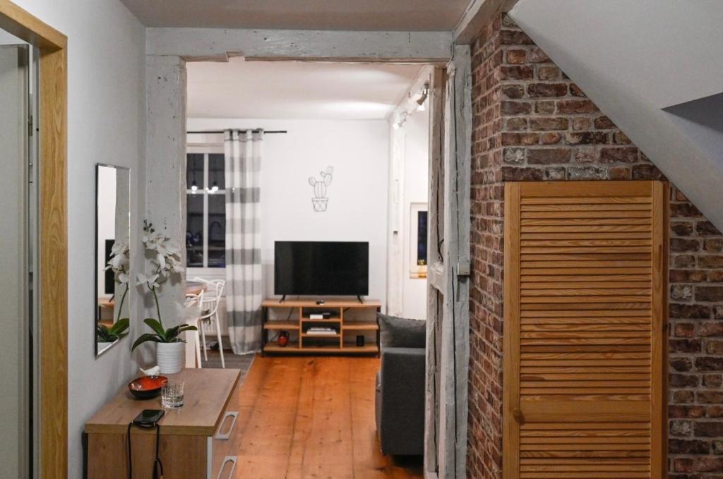 a living room with a brick wall and a television at Kryształowa 47/7 in Piechowice