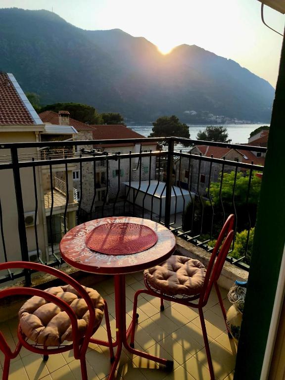 a patio with a table and chairs on a balcony at Sunshine Apartment in Dobrota