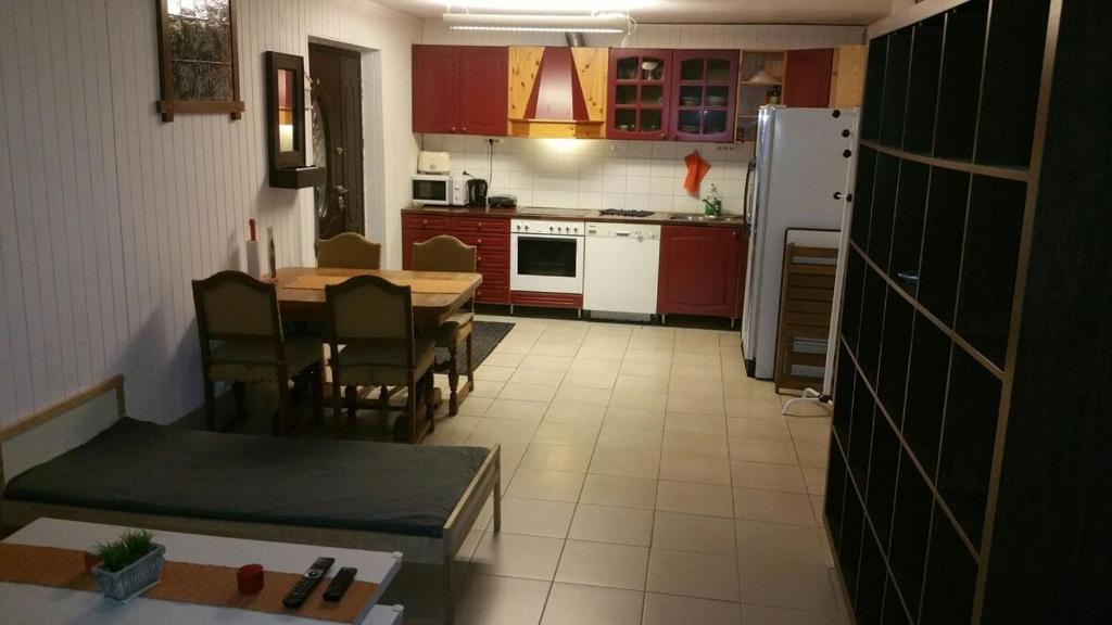 a kitchen with red cabinets and a table and chairs at Billet Junior in Fredrikstad