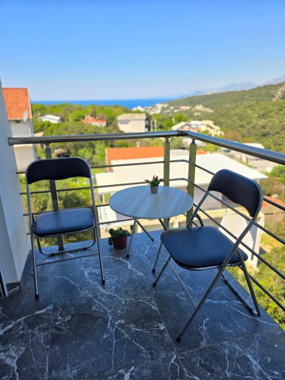 two chairs and a table on a balcony at Brita Apartman in Utjeha