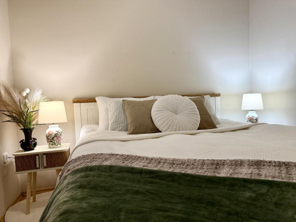 a bedroom with a large green bed with two lamps at Vintage Apartman Gyula in Gyula