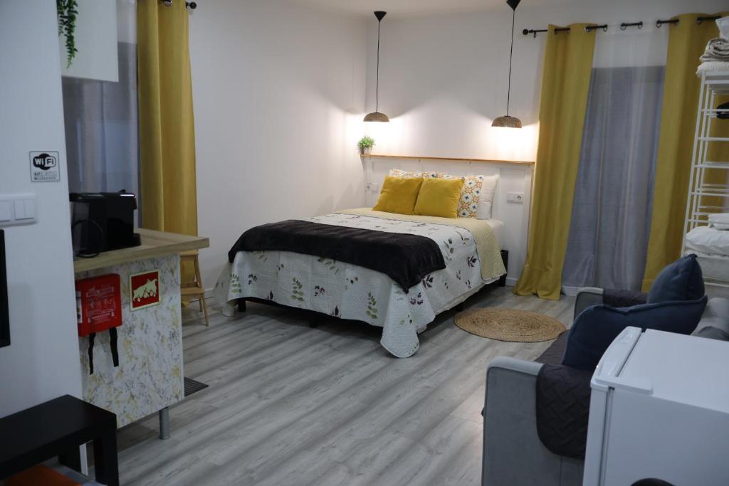 a bedroom with a bed with a yellow pillow at Souto 25 - T0 na Régua in Peso da Régua