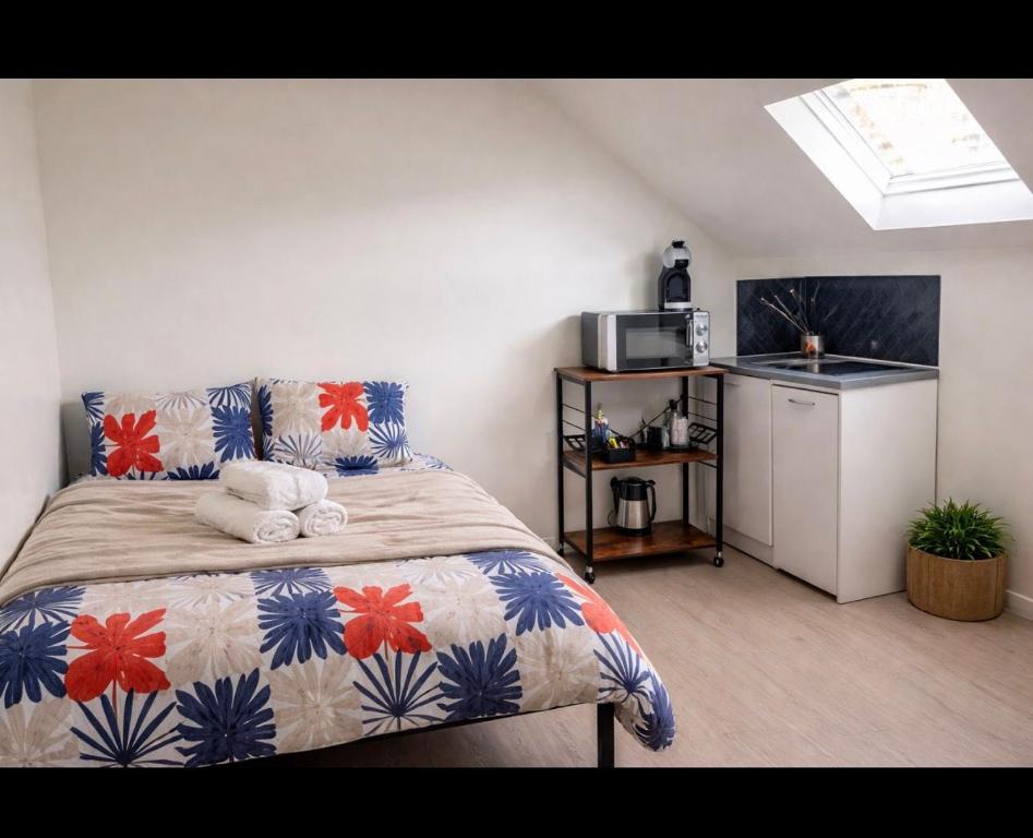 a bedroom with a bed and a kitchen with a microwave at Studio Central Confortable-Entièrement Équipé in Villeneuve-Saint-Georges