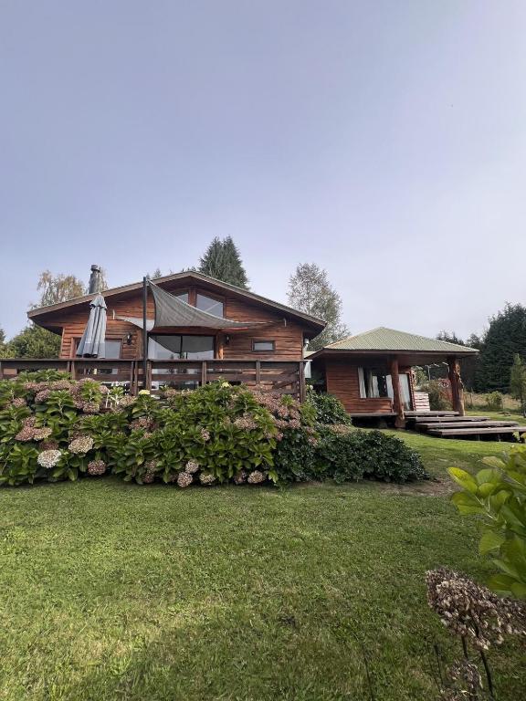 a wooden house with a yard and a house at Cabaña Pino Oregón in Pucará