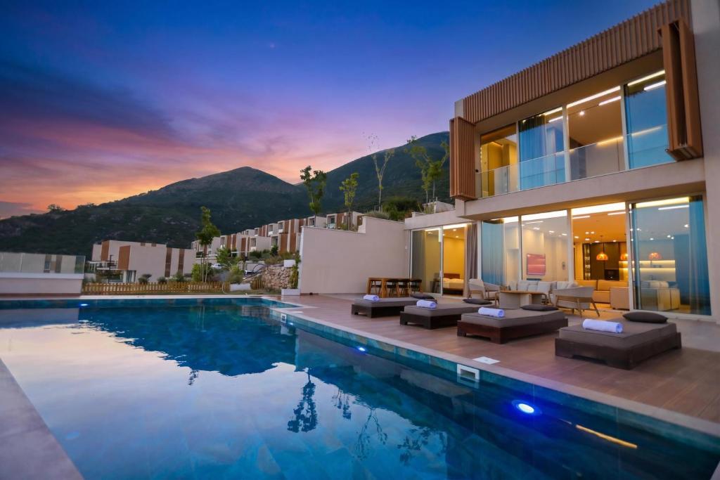 a villa with a swimming pool at dusk at Luxury Pool Villa Palasea With Panoramic Sea View in Vlorë