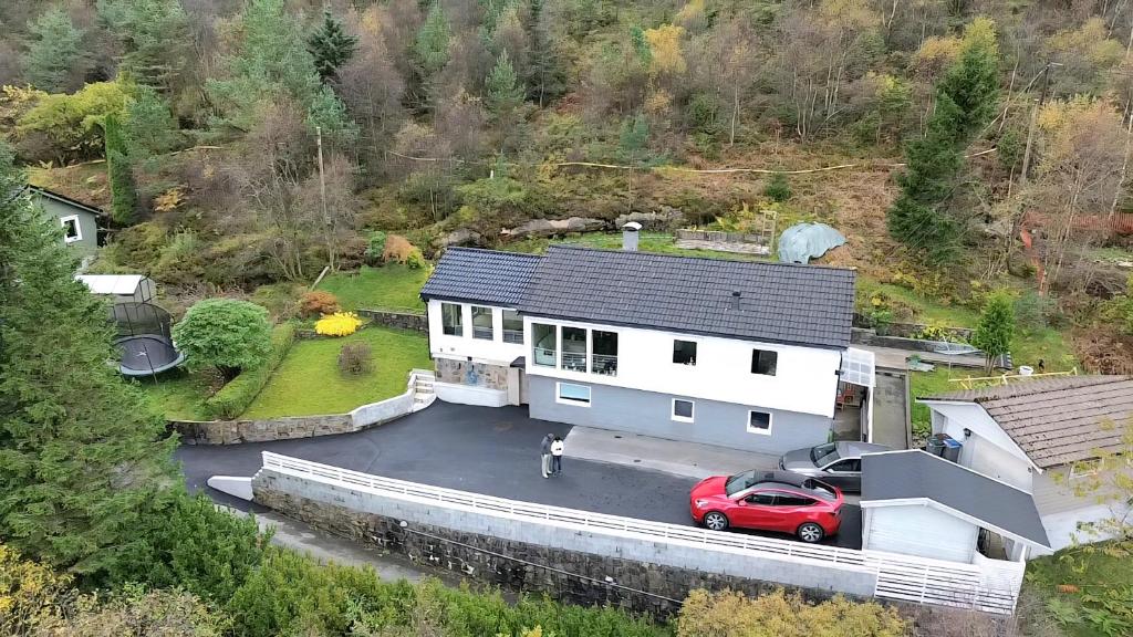 a house with a red car parked in a parking lot at Fjordclaw SNM- adjoining the Bergen city & Nature, Free parking in Bergen