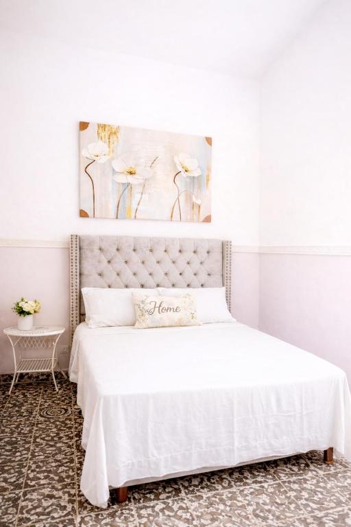 a bedroom with a bed with a white bedspread at H Boutique Blessed in Tela