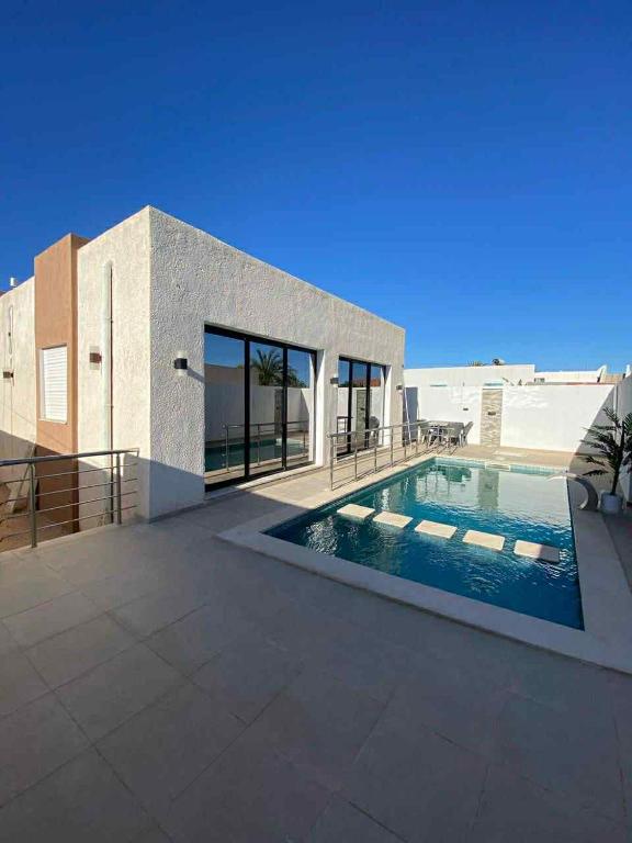 a house with a swimming pool in front of it at Villa SAM in Fafou