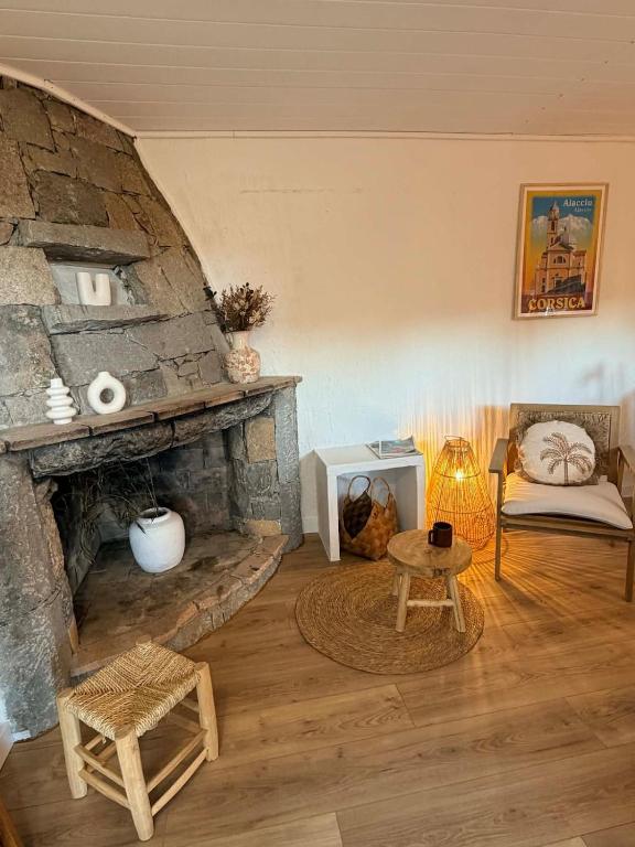 a living room with a stone fireplace and a couch at Caseddu Corse - Maison Typique in Cauro