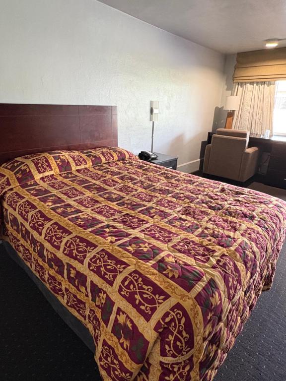 a bed in a hotel room with a colorful bedspread at Hollywood Motel in Middletown