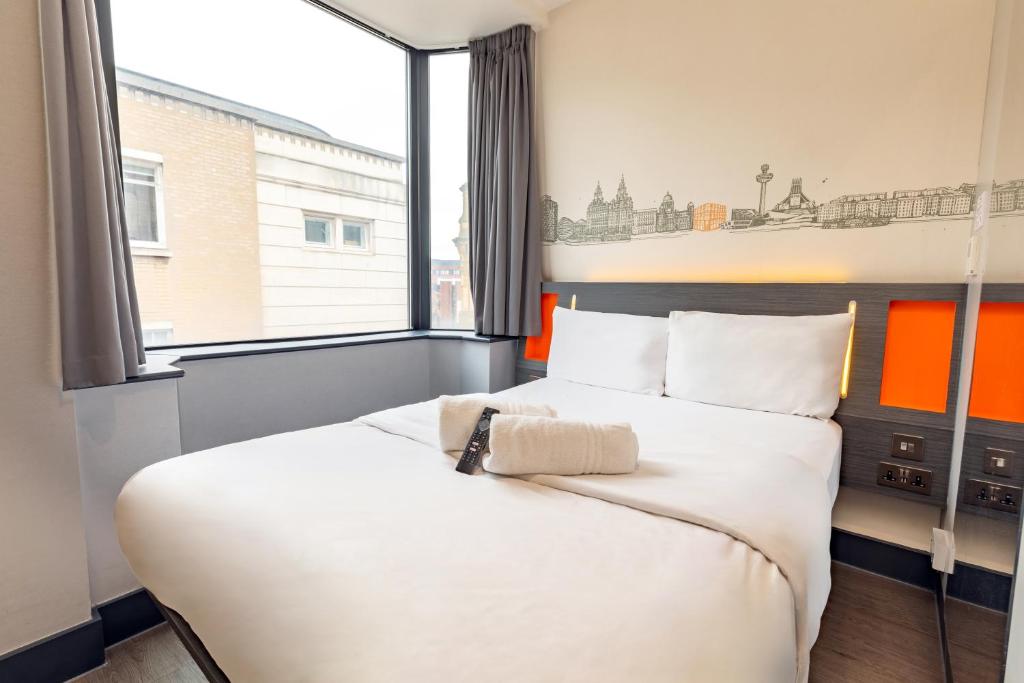 a bedroom with a bed and a large window at easyHotel Liverpool in Liverpool