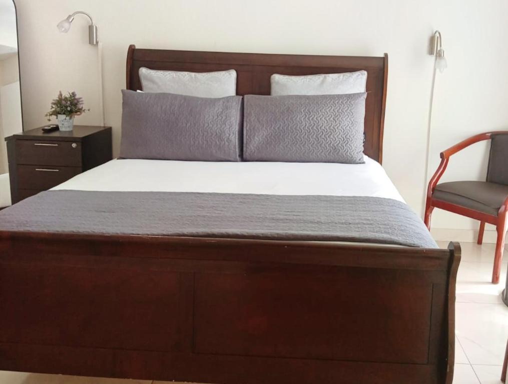 a bedroom with a large bed with a chair and a bed sidx sidx at Durban Oceanic Apartment 82B in Durban