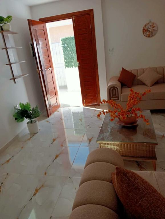 a living room with a couch and a table at Modern and Calm Apartment in Mahdia near Beach in Rejiche