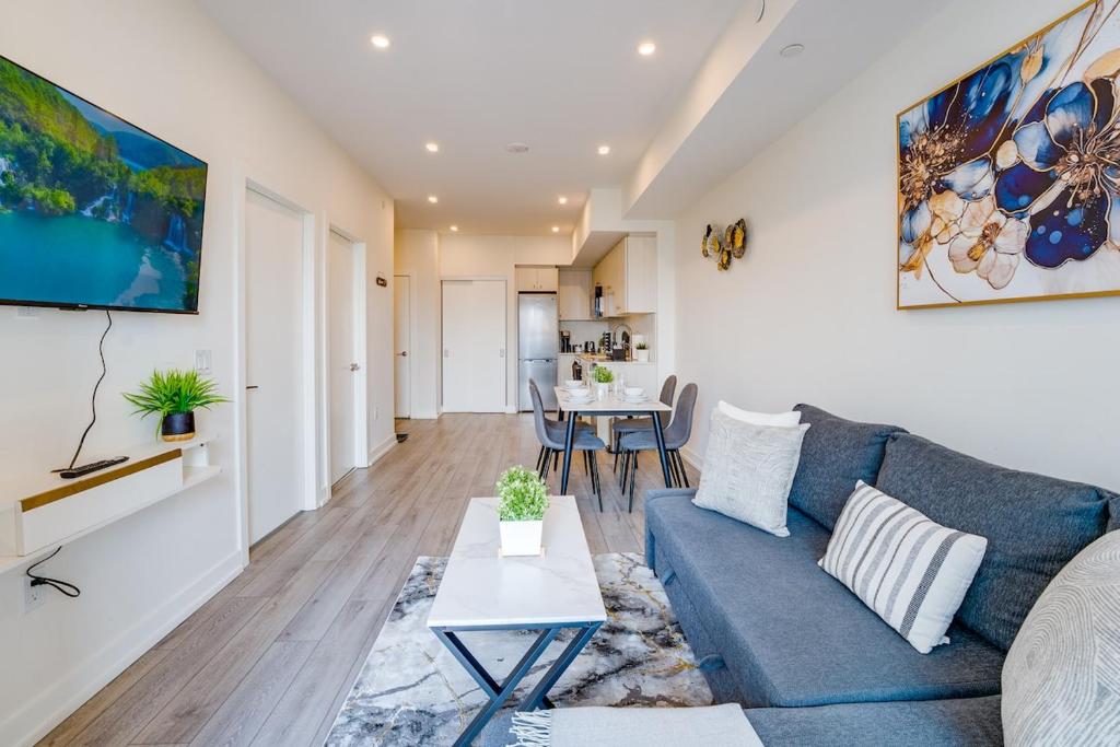 a living room with a blue couch and a table at Stylish Open Concept Condo with Gym in Kitchener