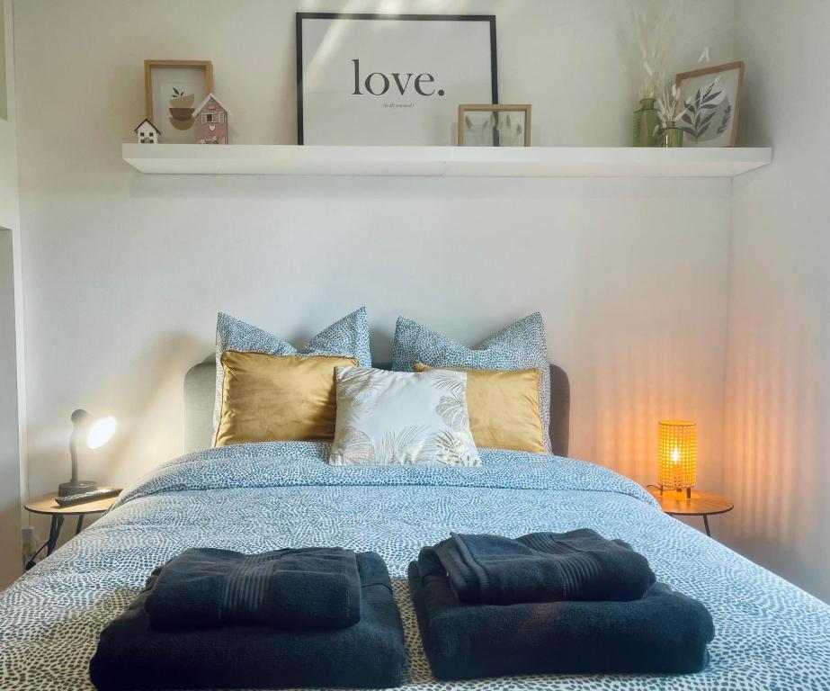 a bedroom with a blue bed with two ottomans at Studio spacieux et calme - Parking facile in La Rochefoucauld