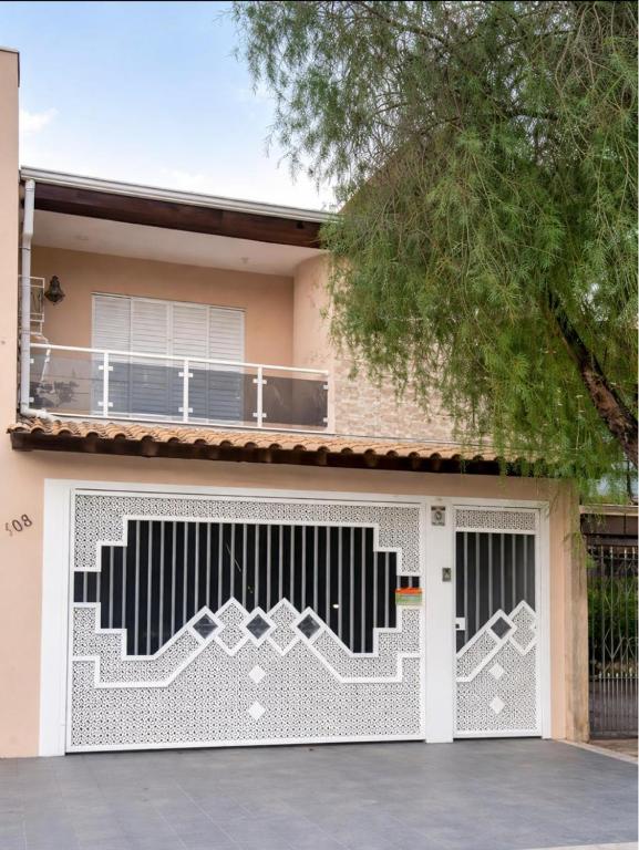 a house with a white and black garage door at Refúgio Aconchego in Sorocaba