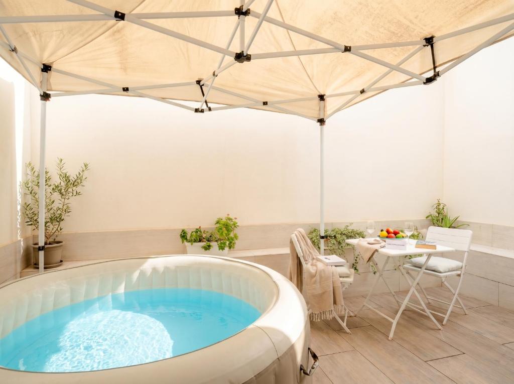 a hot tub in a room with a table and chairs at SPA & RELAX Aesthetic Apartment 50m dal mare in Monopoli