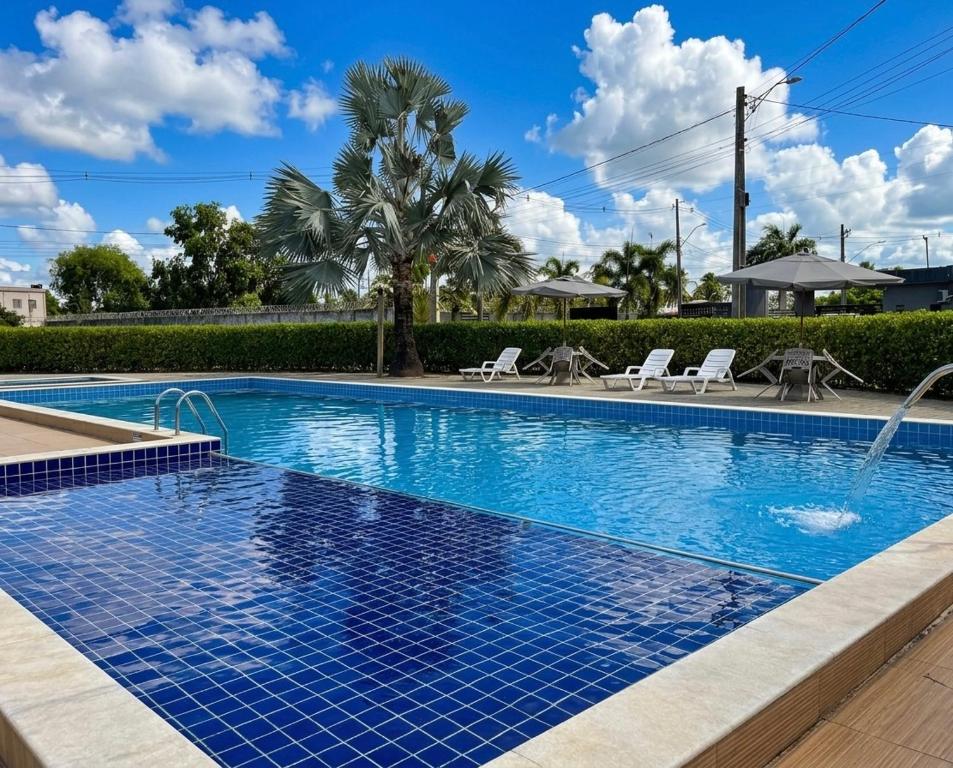 a large swimming pool with blue tiles on it at Casa com Piscina - Condomínio - Próx a Praia in Marechal Deodoro