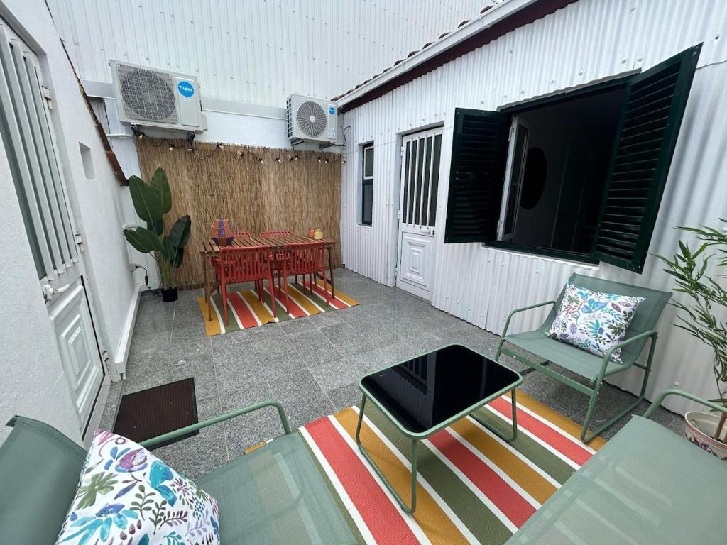 a patio with a table and chairs and a television at Vila Real Center Terrace in Vila Real