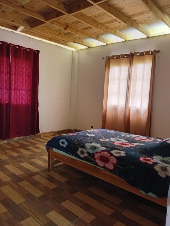 a bedroom with a bed and two windows at Palmeras de Miramar in Miramar