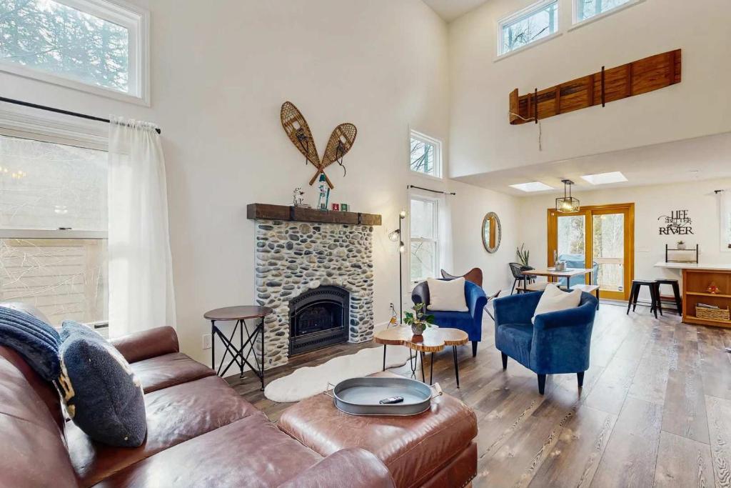 a living room with a couch and a fireplace at Riverfront retreat with panoramic river and forest views in Rhododendron