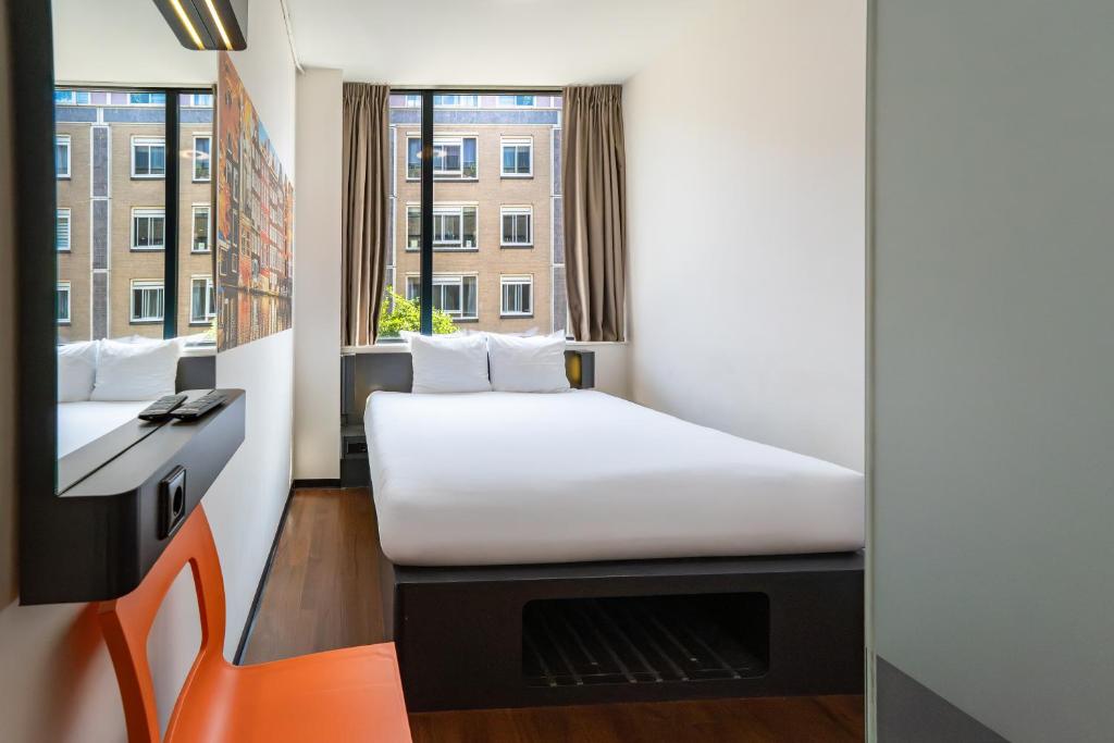 a small room with a bed and a window at easyHotel Amsterdam City Centre South in Amsterdam