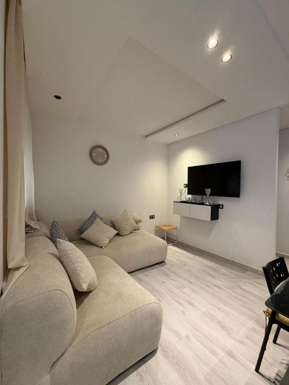 a living room with a couch and a flat screen tv at Appartemet city centre kenitra in Kenitra