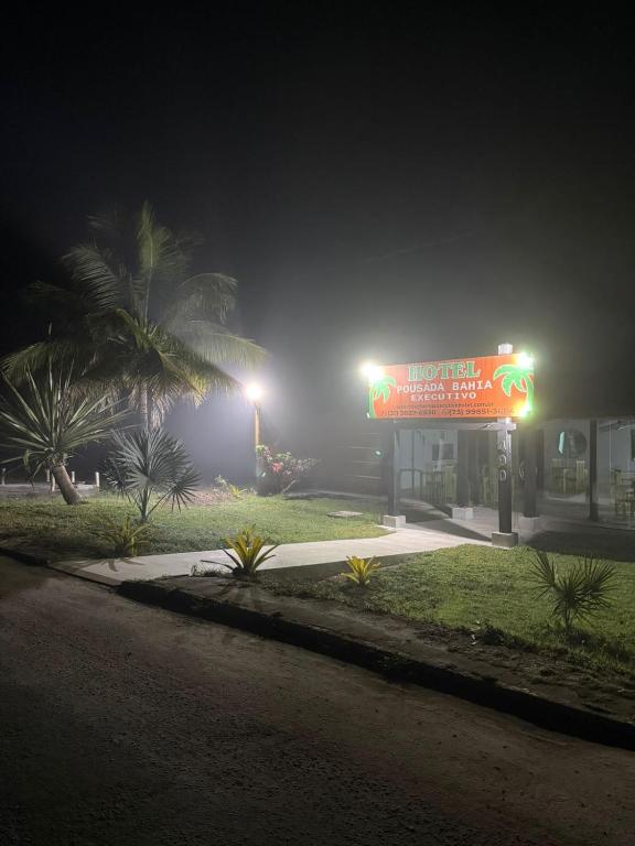 a gas station at night with a sign on it at Bahia Executivo Pousada in Zeca