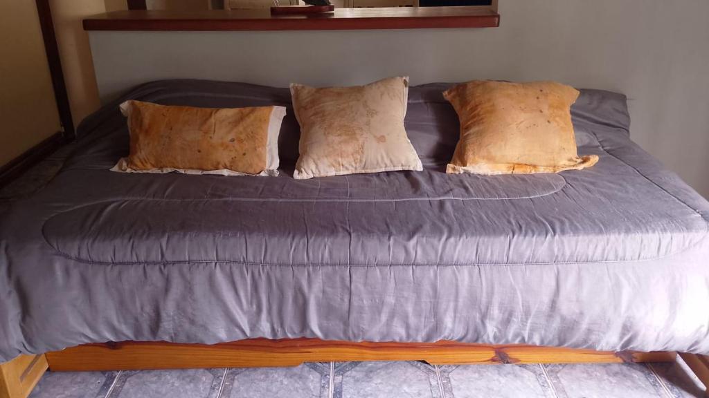 a large bed with brown pillows on it at Brisas Pura in Tandil