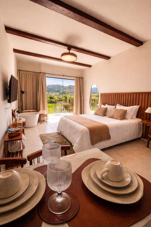 a bedroom with a bed and a table with plates on it at Villa di Trevi Hospedagem em Pedra Azul in Domingos Martins