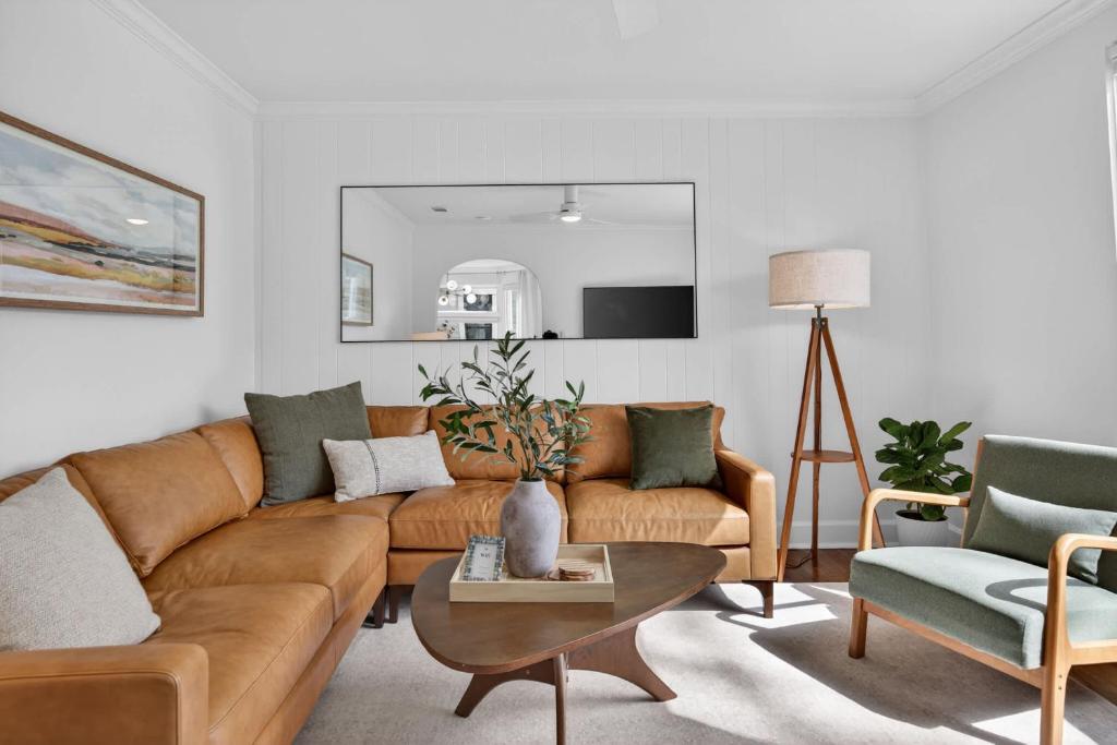 a living room with a brown couch and two chairs at 10th St Retreat in Boise