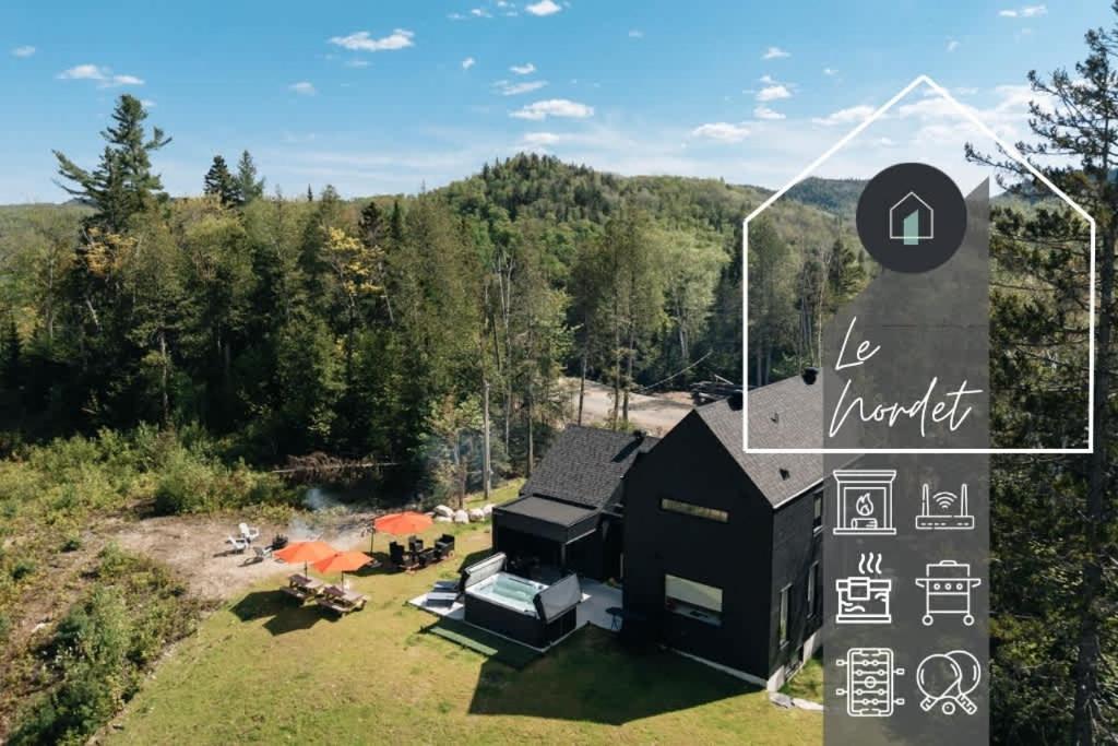 an aerial view of a black house in the woods at Le Nordet - SPA & Play room in Saint Come