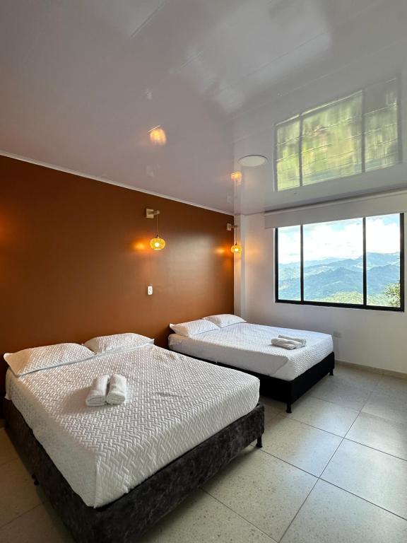 a bedroom with two beds and a large window at Casa Lemora in Vergara