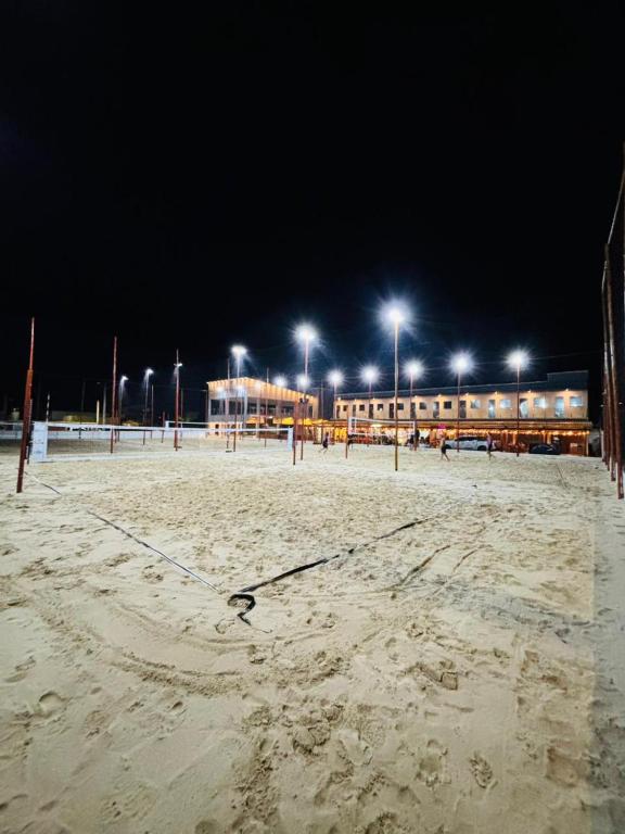 an empty beach at night with street lights at Pousada Complexo Vibe in Baraúna