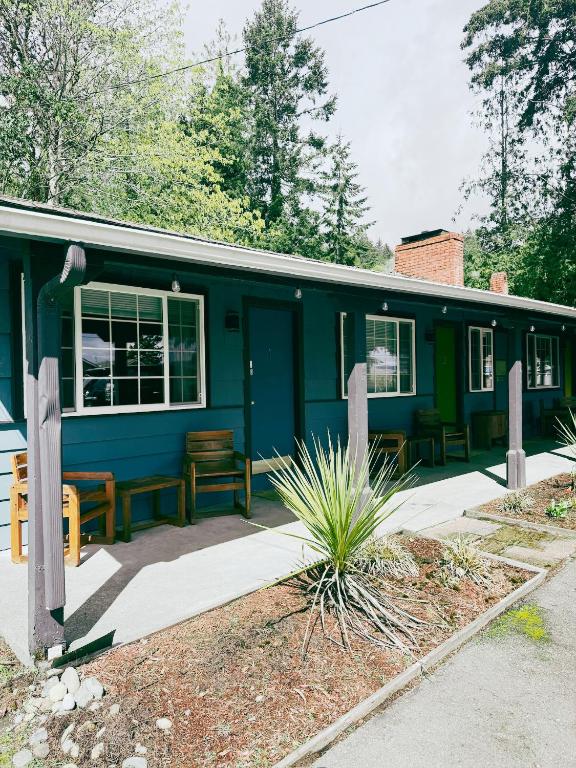 a blue house with windows and a patio at Fjordline Lodge in Hoodsport