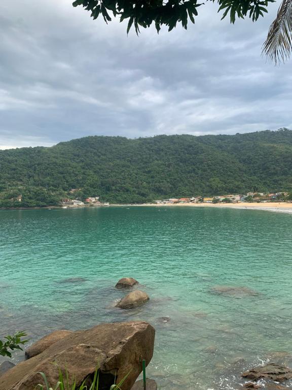 a view of a beach with rocks in the water at vista mar suite luxo in Angra dos Reis