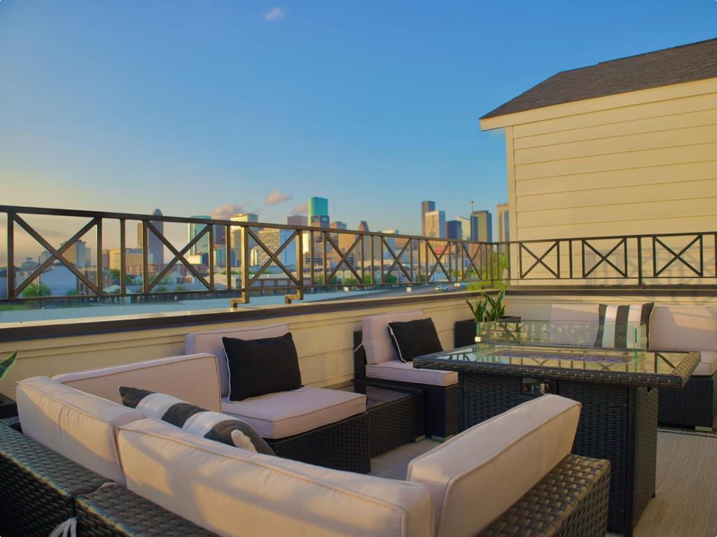 a balcony with a couch and chairs on a roof at The Grand Harris in Houston