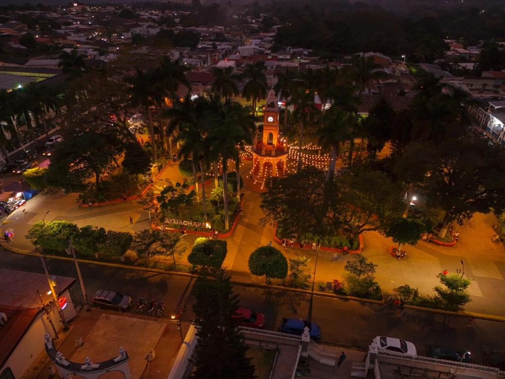 an overhead view of a city at night with a clock tower at La Casa de Mamapán Hotel Colonial Ahuachapan in Ahuachapán