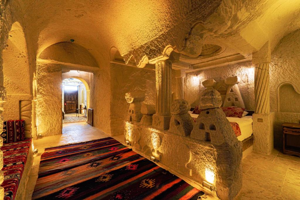 a large room with a bed and a rug at Tyana Cave House in Nar