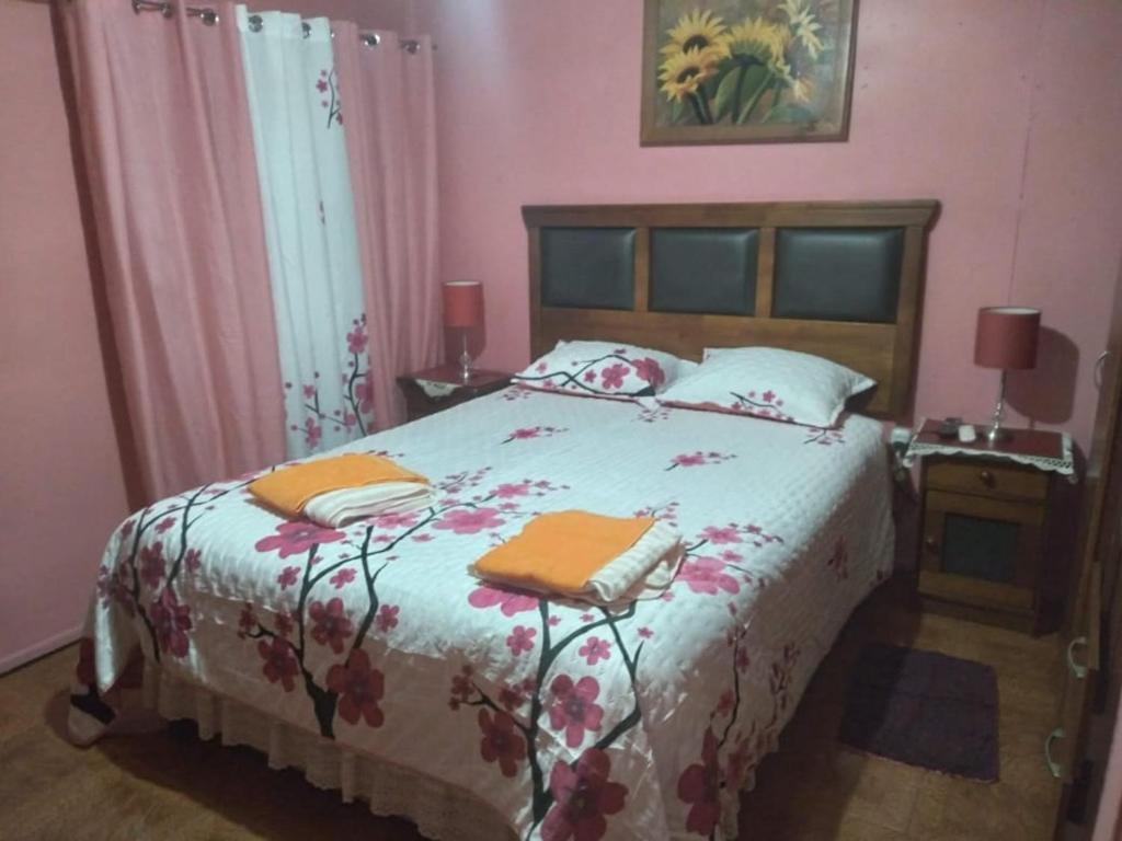 a bedroom with a bed with two towels on it at Hospedaje Domiluis in Coihaique