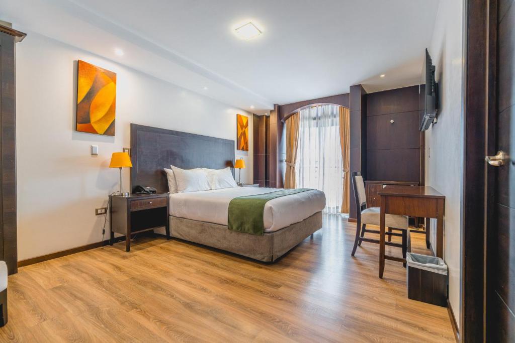 a hotel room with a bed and a desk and a desk at Zamorano Real Hotel in Loja