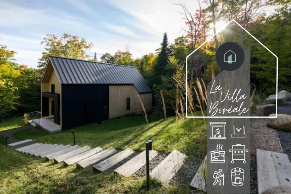 a building with a sign in front of it at Villa Boreale - Wellness and relaxation in Petite-Rivière-Saint-François