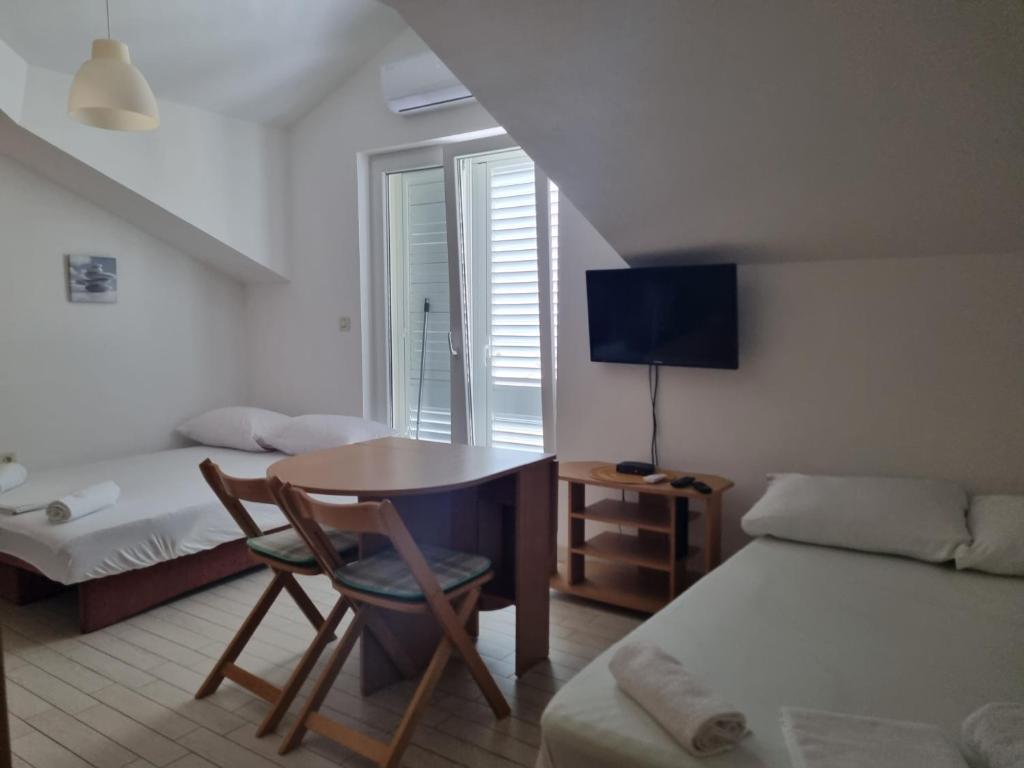 ein Schlafzimmer mit einem Bett, einem Schreibtisch und einem Tisch in der Unterkunft View - Novalja in Novalja