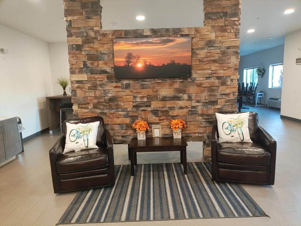 a living room with two chairs and a table at The Grove Inn and Suites in Eagle Grove