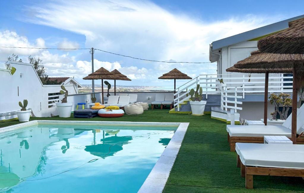 a pool with chairs and umbrellas on a patio at Villa Sara in Ragusa
